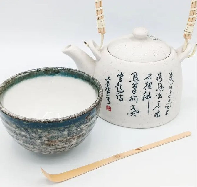 Cuchara Chashaku de bambú para matcha. Se exhibe con cuenco de cerámica esmaltado y tetera japonesa con caligrafía. Accesorio esencial.