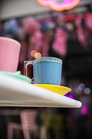 Lattes rosa y azul de Matcha Colors en un bar con luces de neón