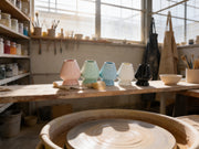 Soportes de ceramica para chasen de Matcha Colors secandose en la estanteria de un taller de alfareria - campaña IA