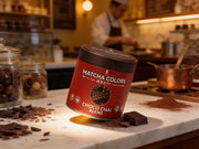 Lata de Choco Chai Blend de Matcha Colors sobre el mostrador de mármol de una chocolatería artesana con virutas de cacao - campaña IA