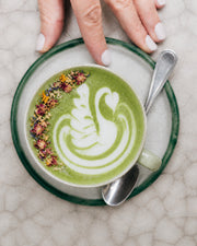 Latte verde de Green Matcha Blend con arte de leche y pétalos, vista cenital