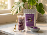 Doypack de Japanese Ube en encimera de mármol con latte helado morado, luz de mañana y monstera - campaña de lanzamiento IA