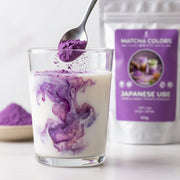 Cuchara de polvo de ube morado creando remolinos en un vaso de leche, doypack de fondo - campaña IA (etiqueta desenfocada)