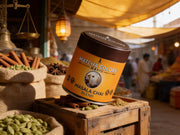 Lata de Masala Chai Blend de Matcha Colors sobre una caja de madera en un bazar de especias indio con sacos de canela y cardamomo - campaña IA