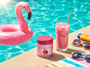 Lata de Pink Matcha Blend con un latte rosa helado al borde de la piscina y un flotador de flamenco al fondo - campaña IA