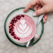 Latte rosa de Pink Matcha Blend con arte de leche y pétalos, vista cenital