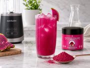Batido rosa de pitaya con licuadora y lata de Matcha Colors en mármol
