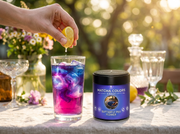 El momento mágico: jugo de limón cayendo en un té helado de flor de guisante mariposa que pasa de azul a violeta y rosa, con la lata Butterfly Pea Flower al lado - campaña IA