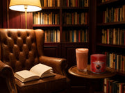 Lata de Rooibos Powder de Matcha Colors con un latte rojo en un rincón de lectura con sillón vintage y biblioteca - campaña IA