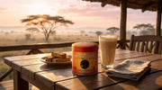 Lata de Vanilla Rooibos Powder de Matcha Colors en una mesa de lodge al amanecer en la sabana con latte cremoso y bizcochos - campaña IA