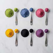 Flat lay de seis polvos de colores de Matcha Colors cada uno con su cuchara medidora de acero - campaña IA